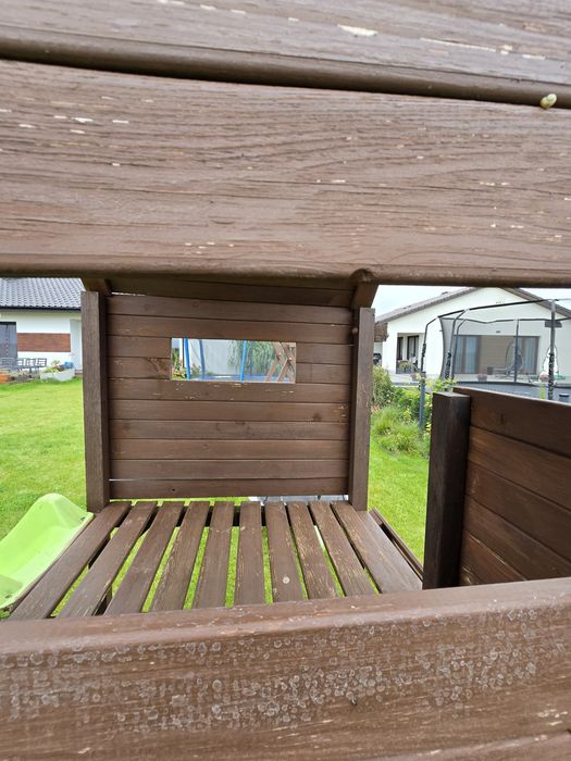 Drewniany plac zabaw z domkiem, zjeżdżalnią, huśtawką i ścianką wspina