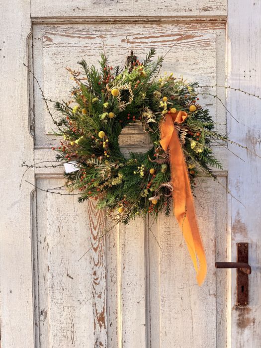 Jesienny wianek z gałązkami modrzewia i pomarańczową kokardą