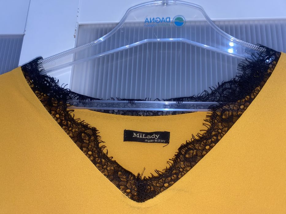 Musztardowa sukienka z koronkowym dekoltem i falbankami