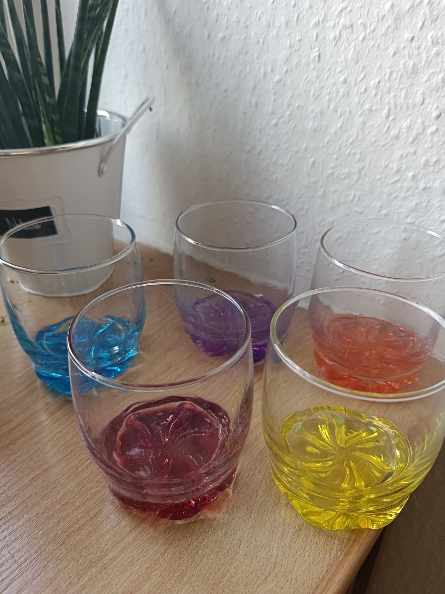 Zestaw szklanek z kolorowymi spodkami.