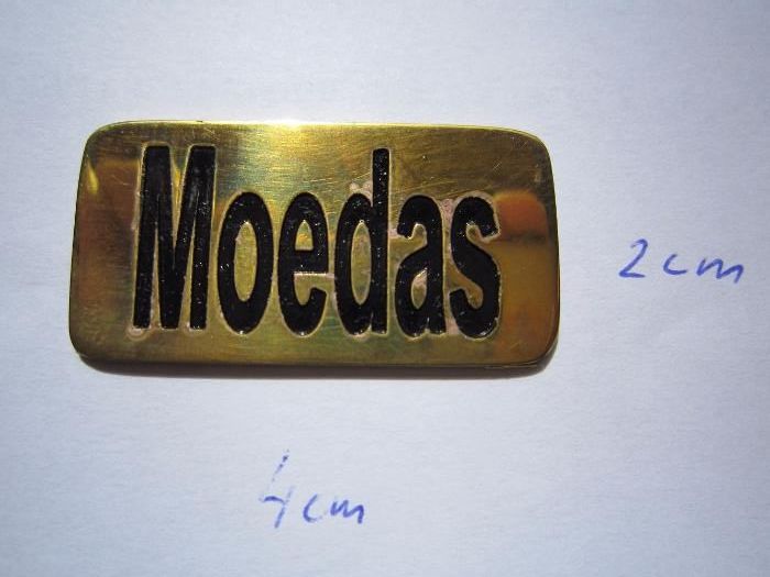 Chapa em latão gravada com a palavra "moedas"