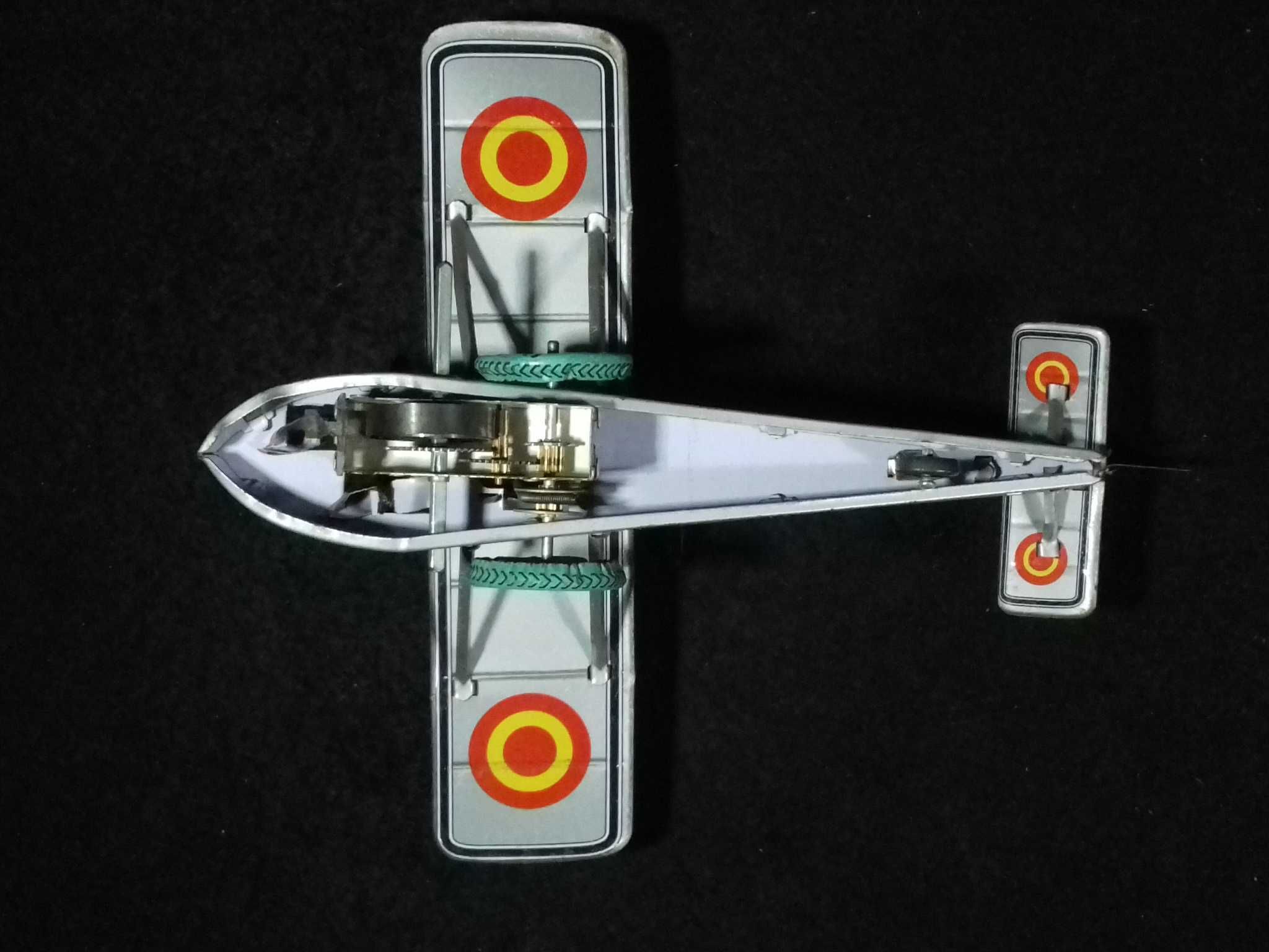 Miniatura de avião antigo em metal, com sistema mecânico de corda;
