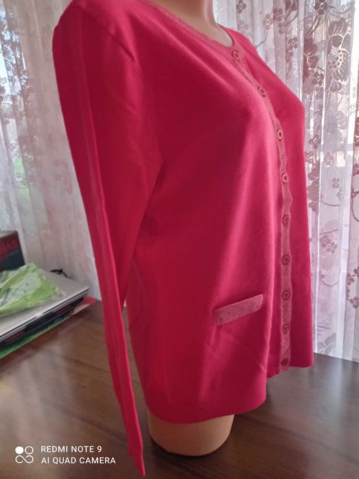 Duży ładny czerwony, damski sweterek z ozdobnym zapięciem.
