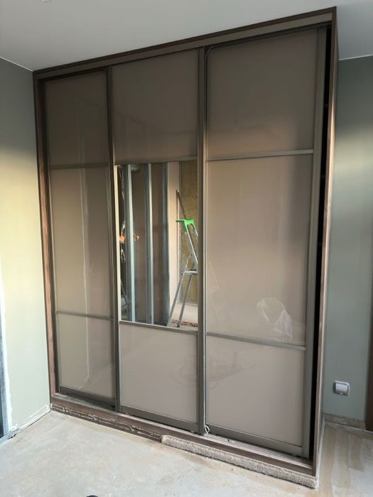 Duża szafa z lustrem i drzwiami przesuwnymi.