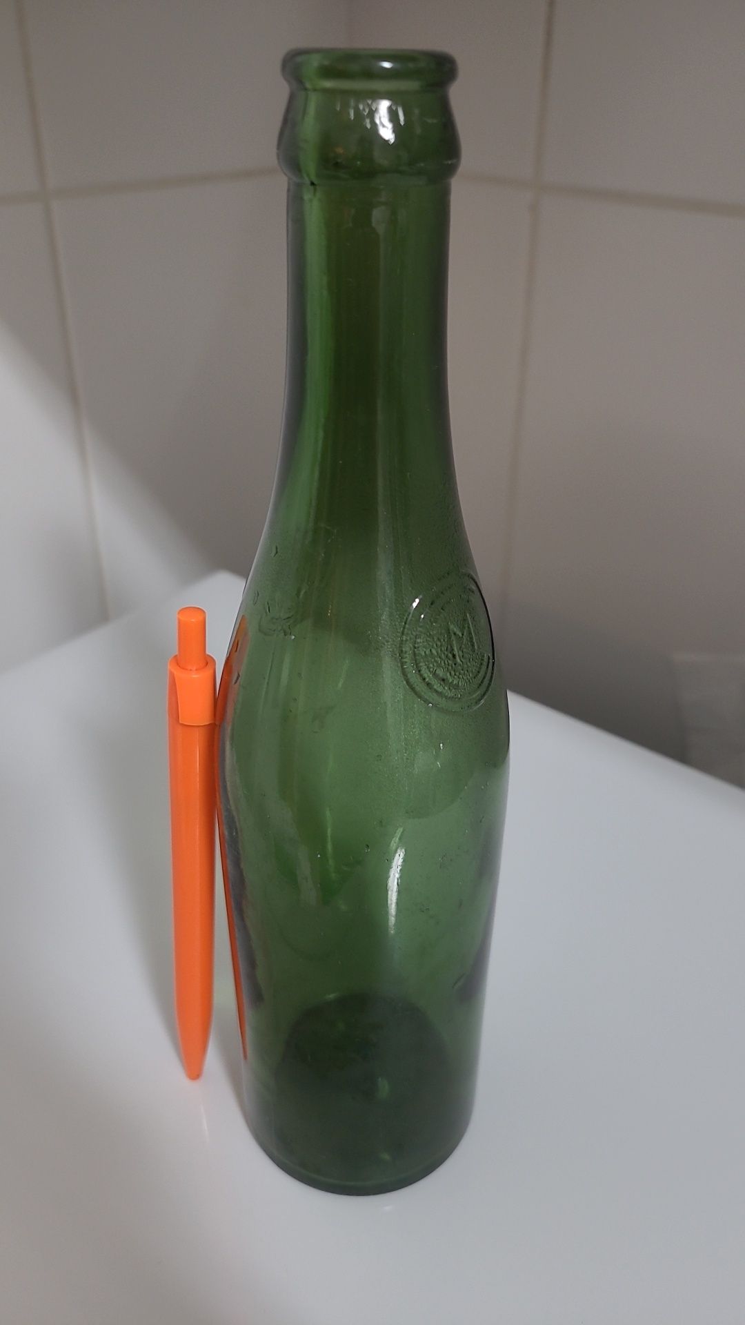 Antiga garrafa de cerveja gravada em alto relevo nas laterais