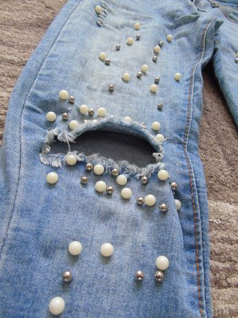 spodnie jeansy z dziurami na kolanach i perełkami