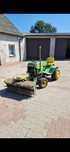 John Deere 300 – traktorek z zamiatarką, wiertnicą, glebogryzarką, kos