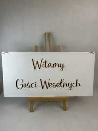 Biała tablica z napisem witamy gości weselnych