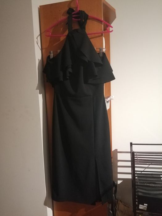 Vestido preto, elegante, com folho no peito. Alça a atar no pescoço.