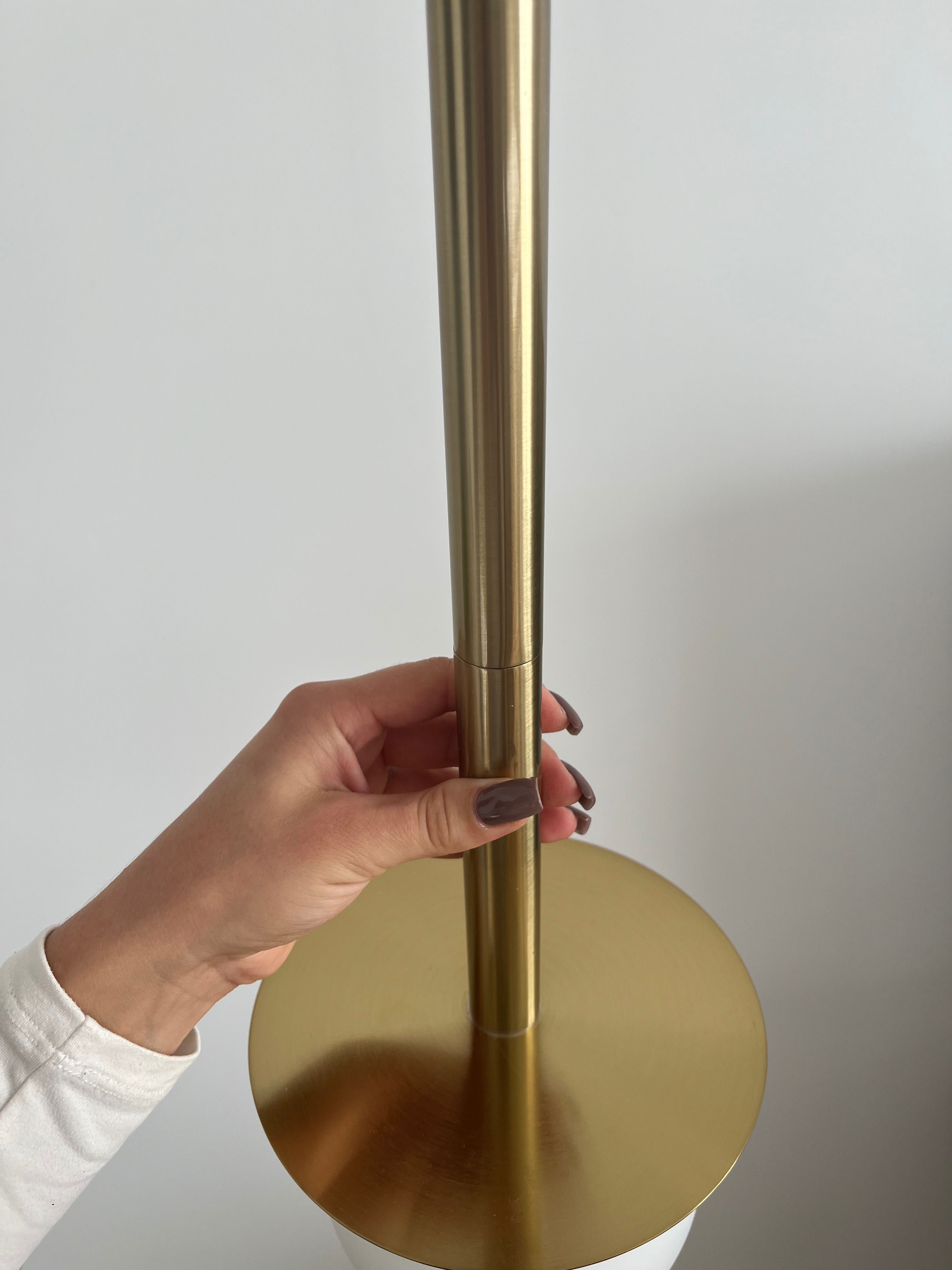 Złota lampa z białą kulą
