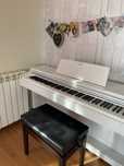Piano branco, com apoio para partituras, banco do piano incluído