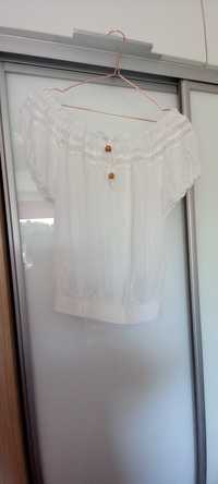 Biała bluzka wykończona koronką i gumka na dole.