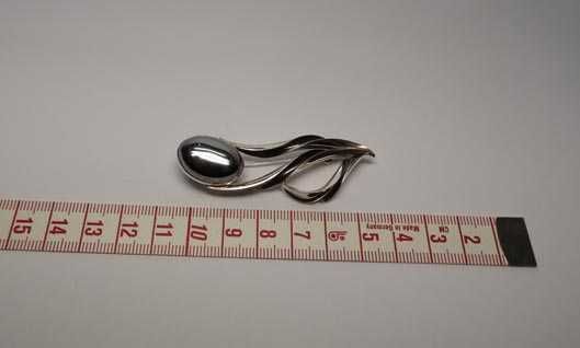 Srebrna broszka z hematytem.