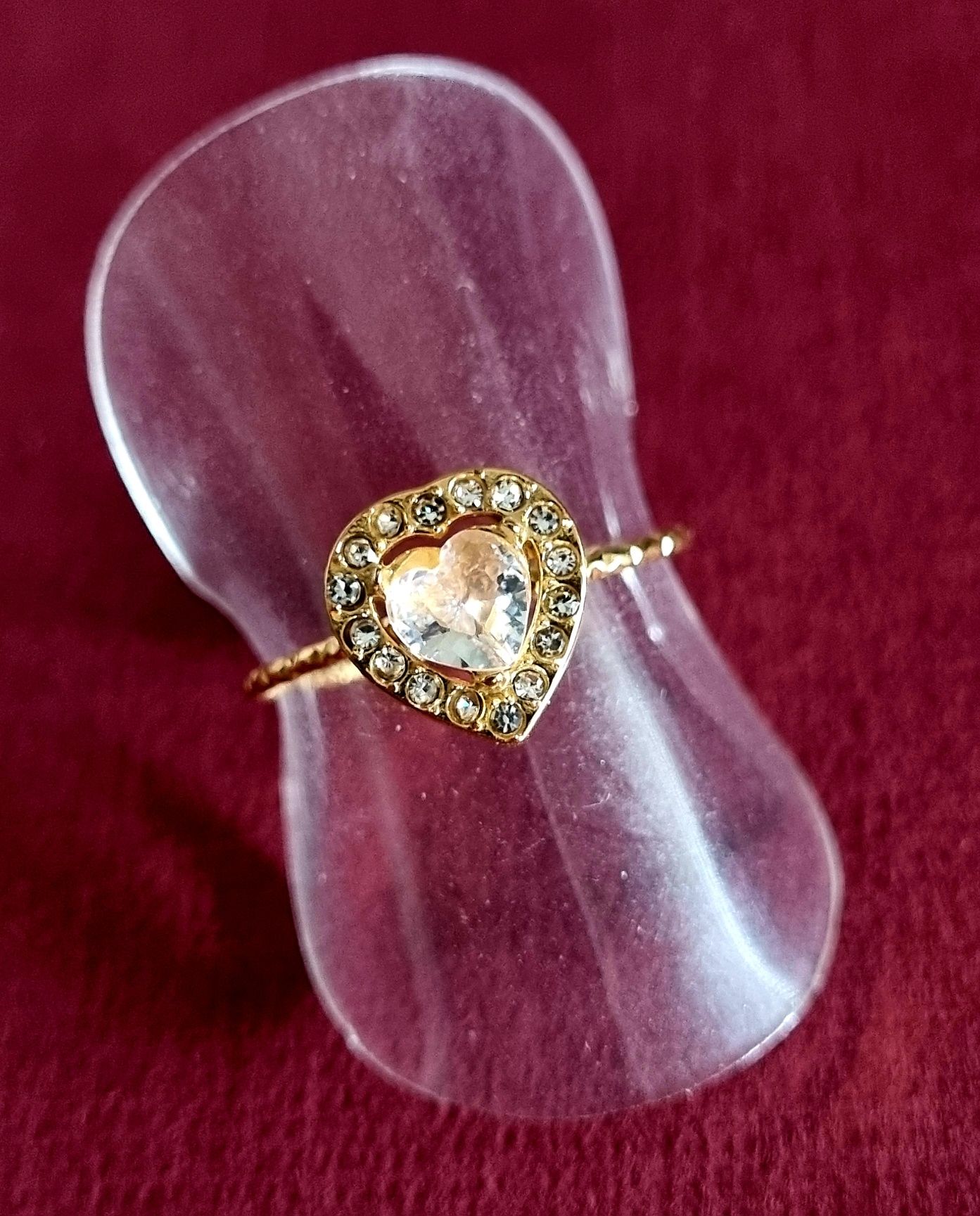 Anel dourado, em aço, coração transparente rodeado de zirconias. Ajust
