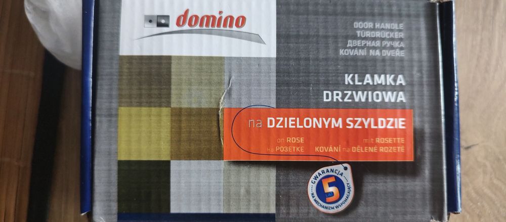 Klamka drzwiowa na dzielonym szyldzie
