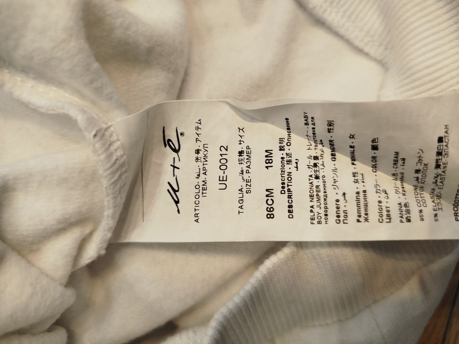 Biała bluza bawełna 80 86 z ozdobną odpinaną dekoracja na dekolcie.