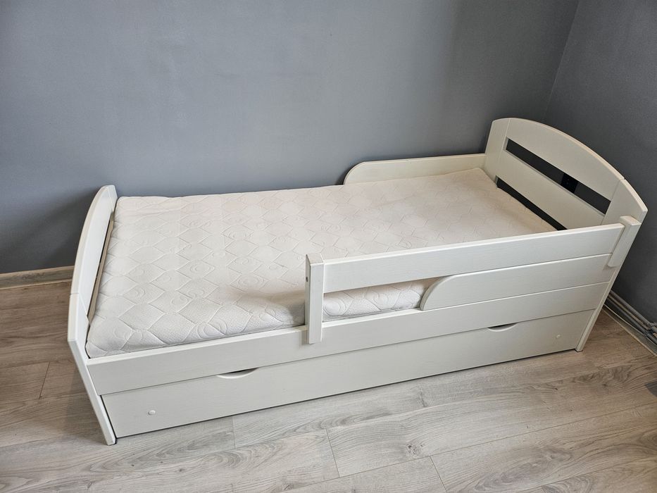 Białe łóżko ze zdejmowaną barierką i szufladą do przechowywania