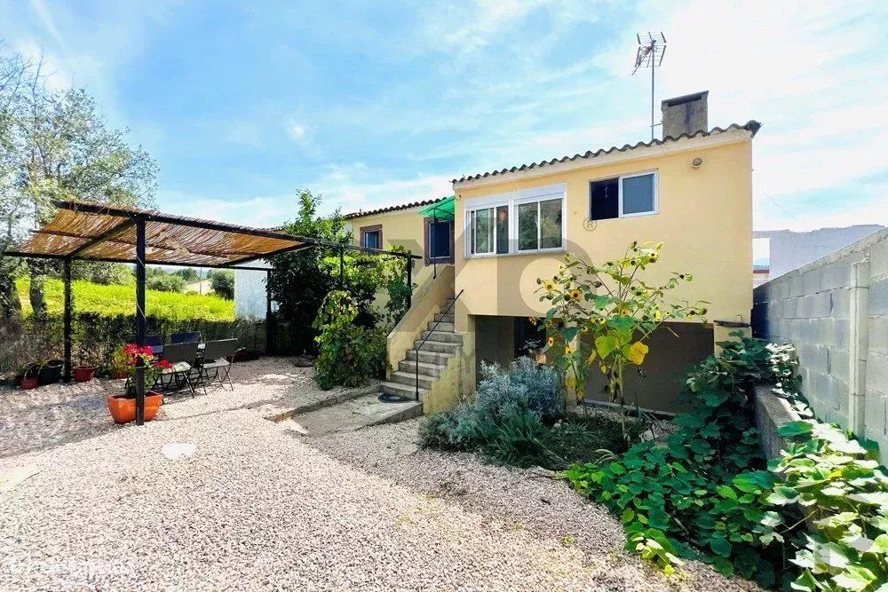 Charmosa casa de família com dois anexos e uma ruína