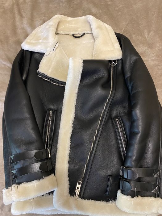 Жіноча дублянка чорного кольору з білим штучним хутром усередині.