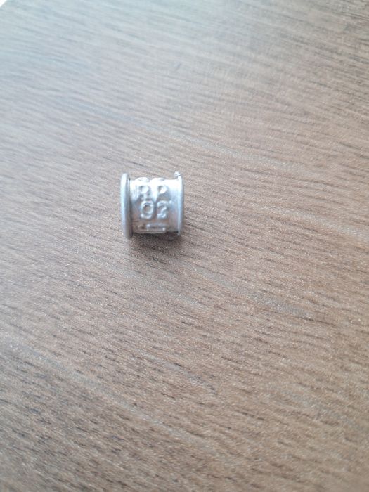 Stara aluminiowa obrączka dla gołębia.