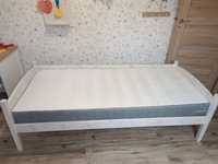 Drewniane łóżko że stelażem i materacem