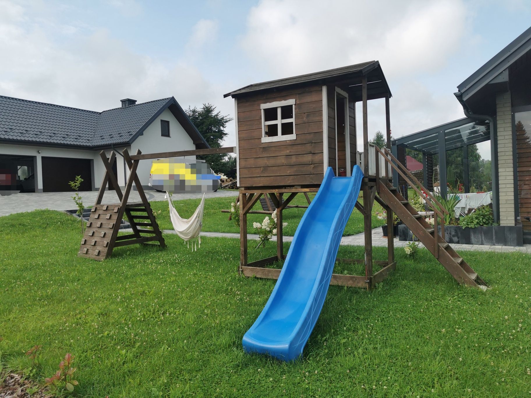 Drewniany domek dziecięcy że ślizgiem.