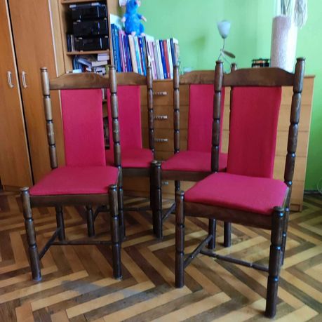 Krzesła drewniane z czerwonym obiciem.