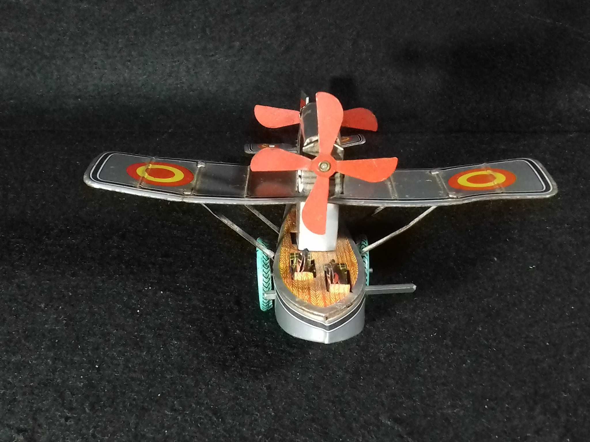 Miniatura de avião antigo em metal, com sistema mecânico de corda;