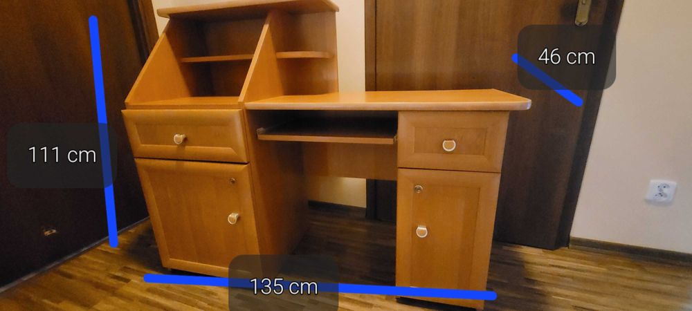 Biurko z szufladami i zamykanymi pułkami.