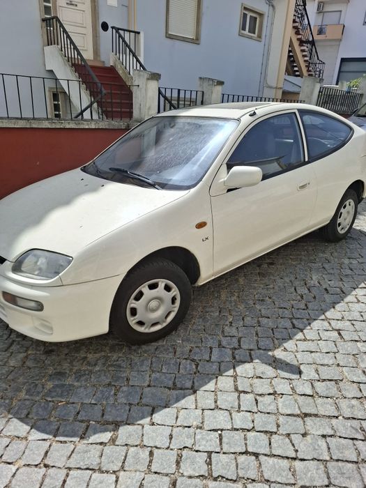 Carro branco-Mazda 323 c/ teto de abrir