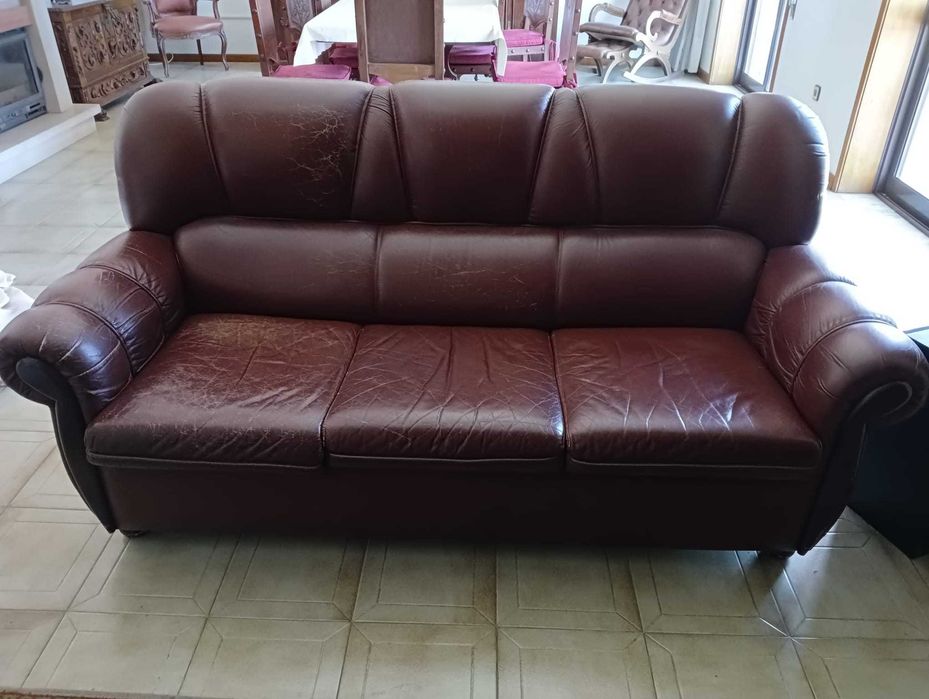 Sofá de três lugares e 2 poltronas em couro castanho.