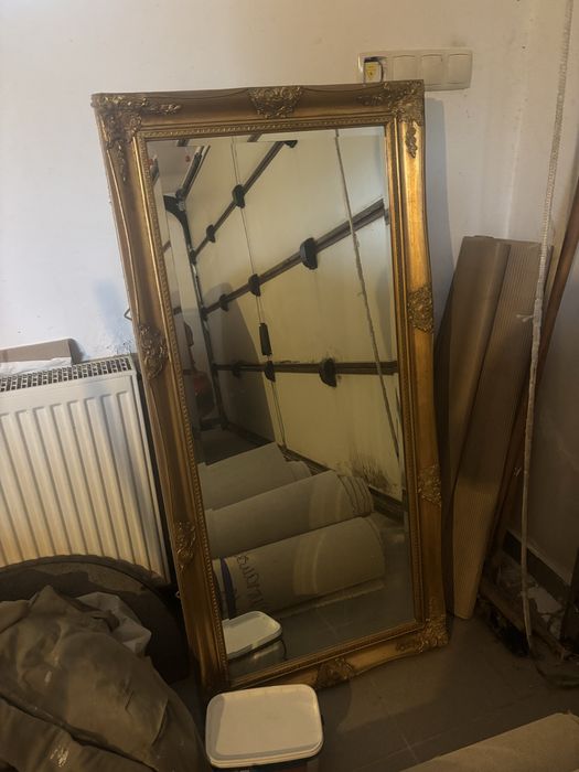 Duże lusto w ozdobnej złotej ramie