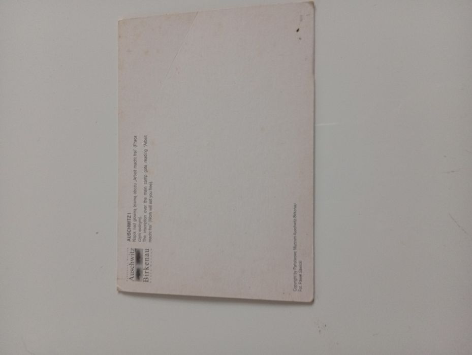 Pocztówka napis nad glona bramą obozu