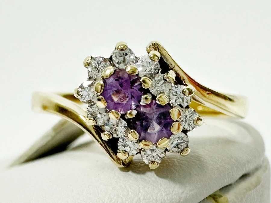 Uroczy damski pierścionek wykonany ze złota z fioletowymi oczkami