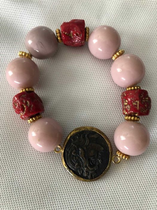 pulseira com bolas rosa e medalha muito bonita  com detalhes originais