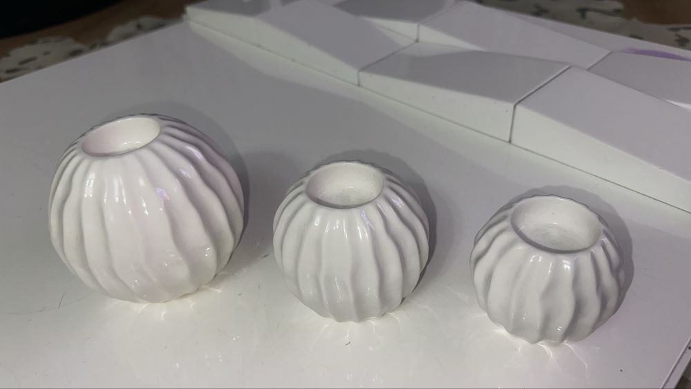 três bolas decorativas com suporte para velas