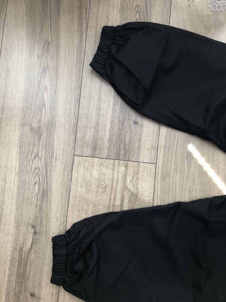Czarne spodnie swiecacy material