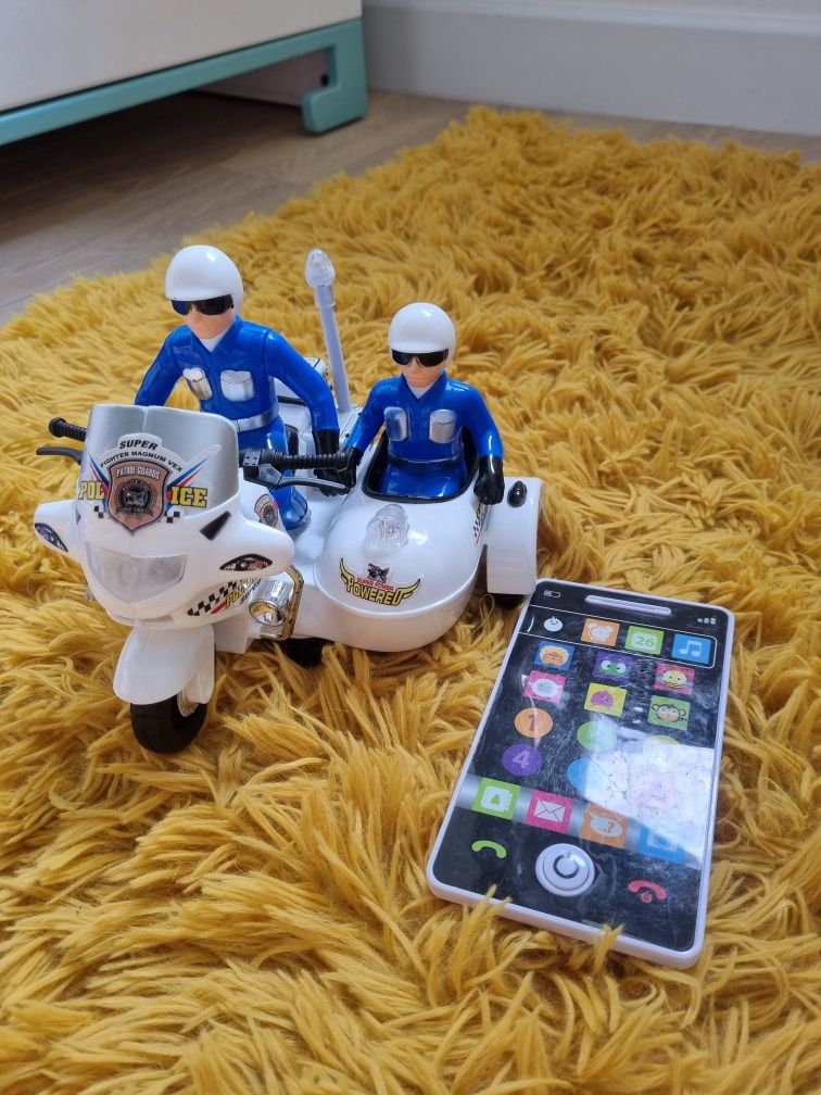 Zabawka policja na motorze i smartfon