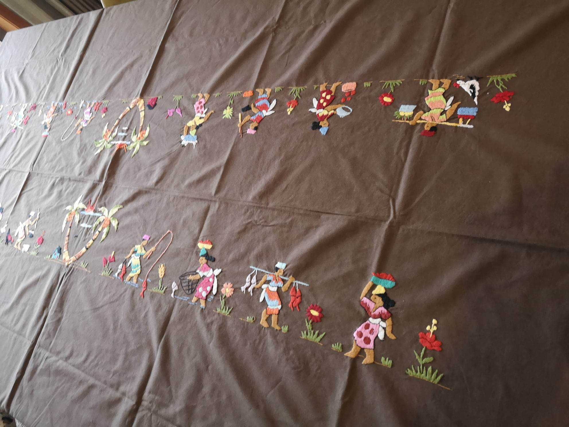 Toalha castanha com figuras coloridas e com guardanapos