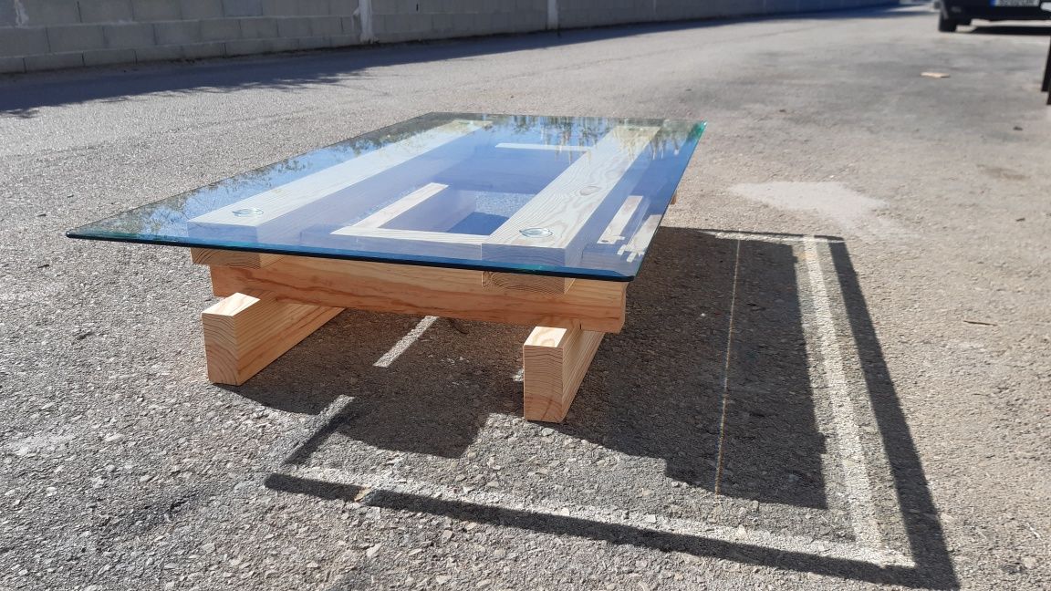 Mesa simples de pinho com vidro detalhado.