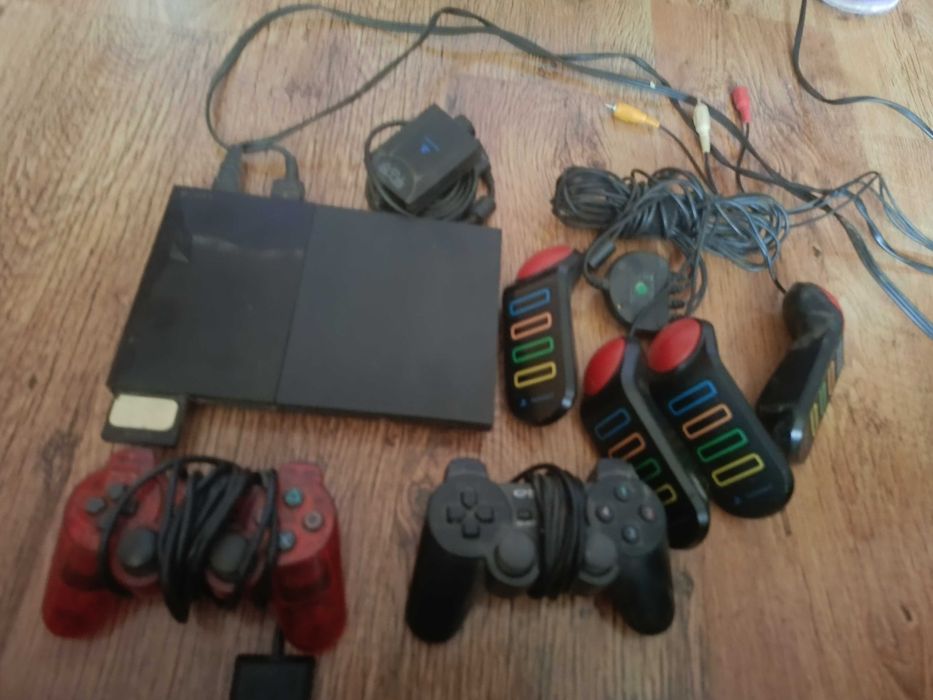 PlayStation 2 + pady + Kierownica + kontrolery BUZZ + kamerka + gry