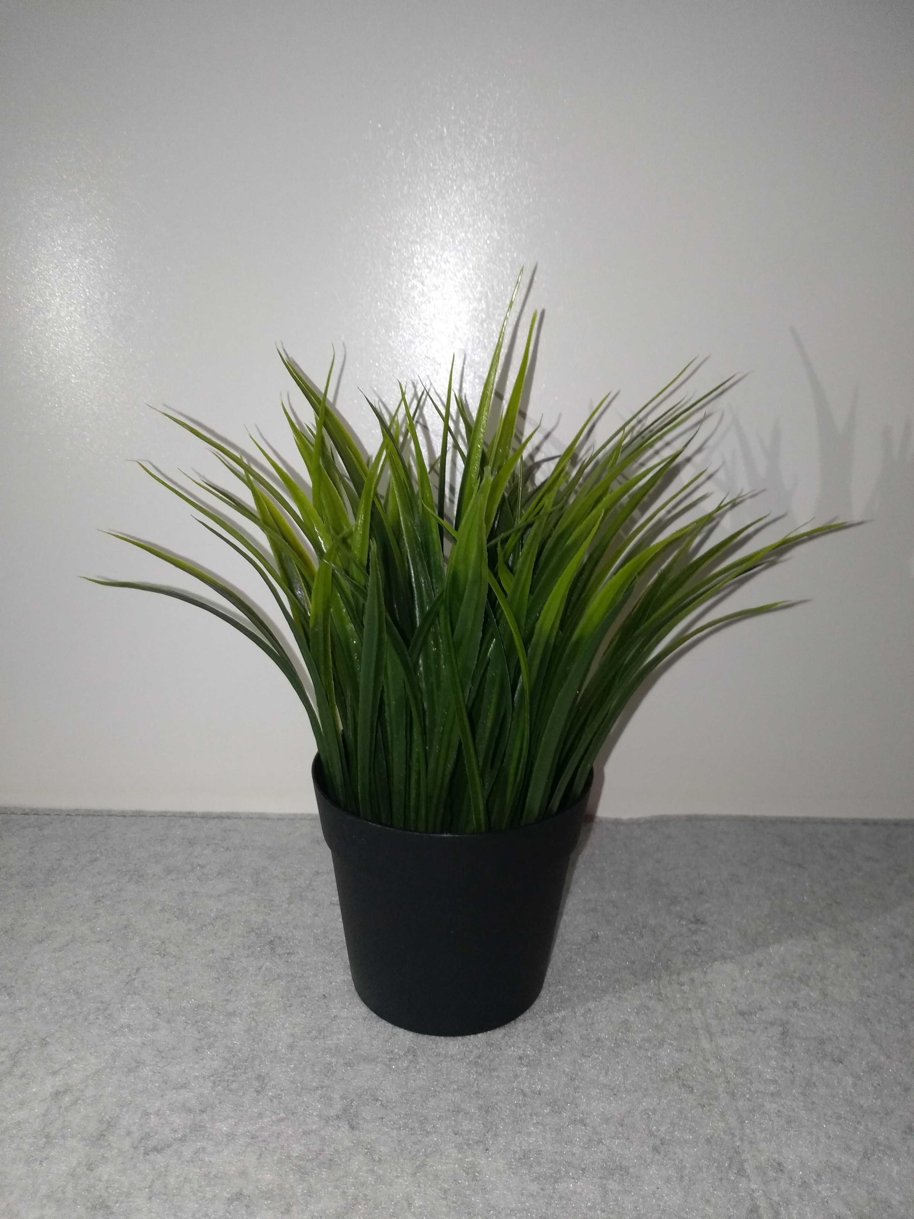 Elegancka sztuczna roślina trawa w ciemnoszarej osłonce ceramicznej