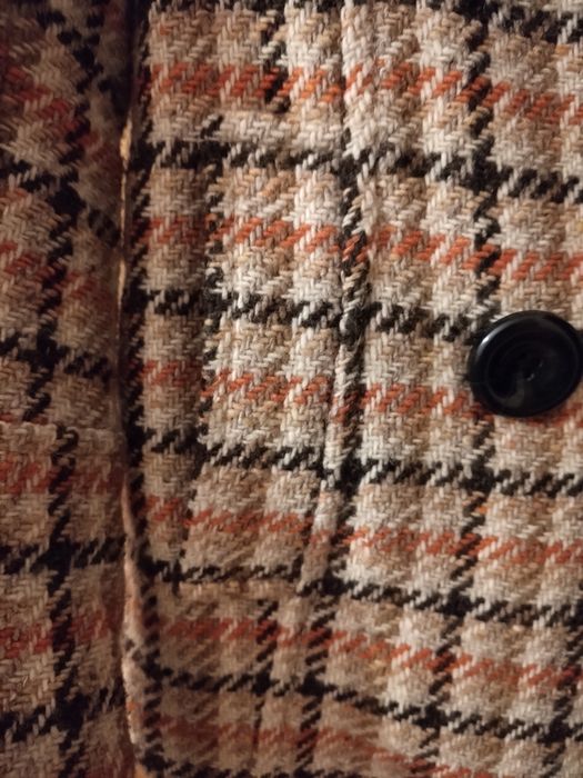 Casaco padrão xadrez castanho, laranja e bege.