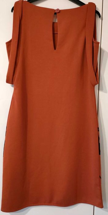 Nowa, elegancka sukienka z ozdobnym motywem.