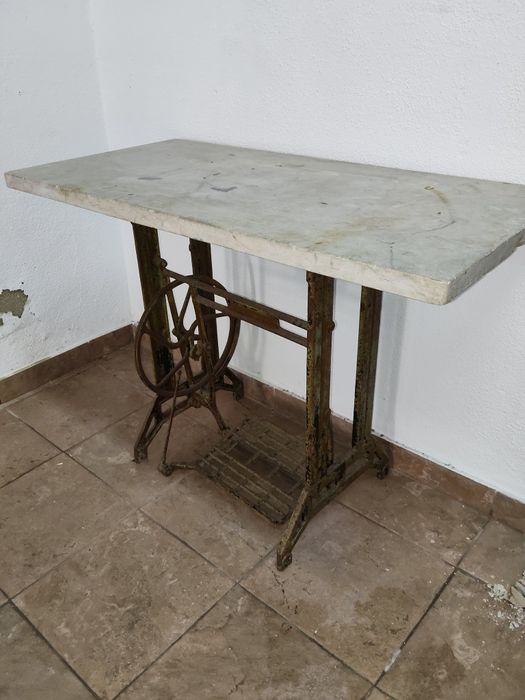Mesa antiga com base de máquina de costura em ferro e tampo de mármore
