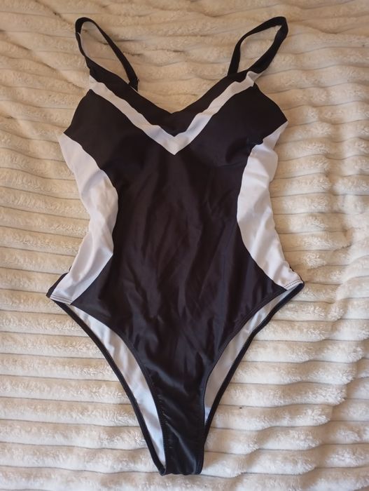 Купальник суцільний, чорний з білими вставками.