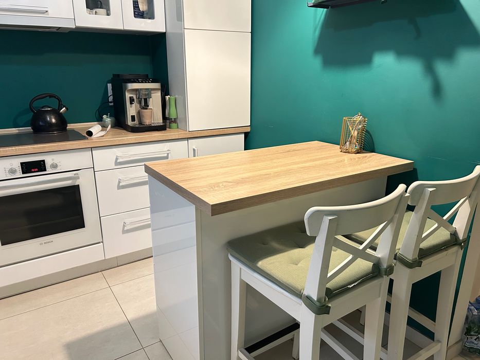 Kuchnia z wyspą kuchenną i krzesłami