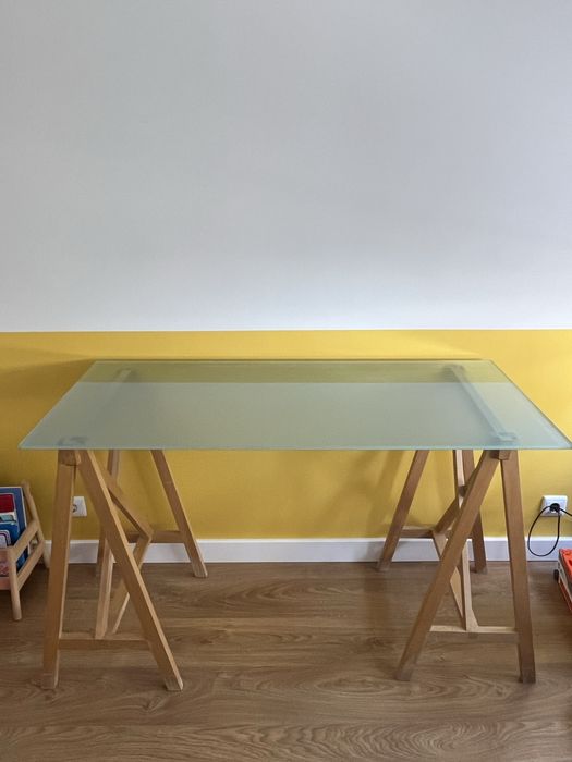 Secretária com tampo de vidro e cavaletes em madeira