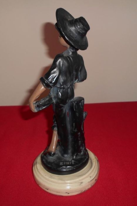 Bonito e elegante par de estatuetas em marfinite, com 25 cm de altura.