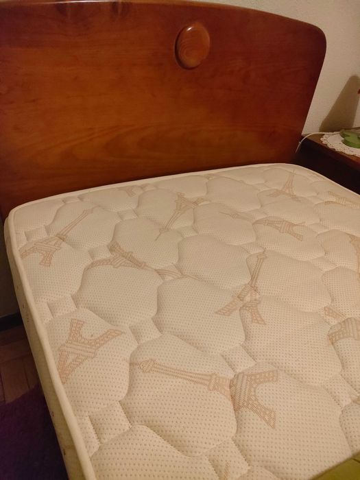 Quarto com cama, mesa de cabeceira e roupeiro